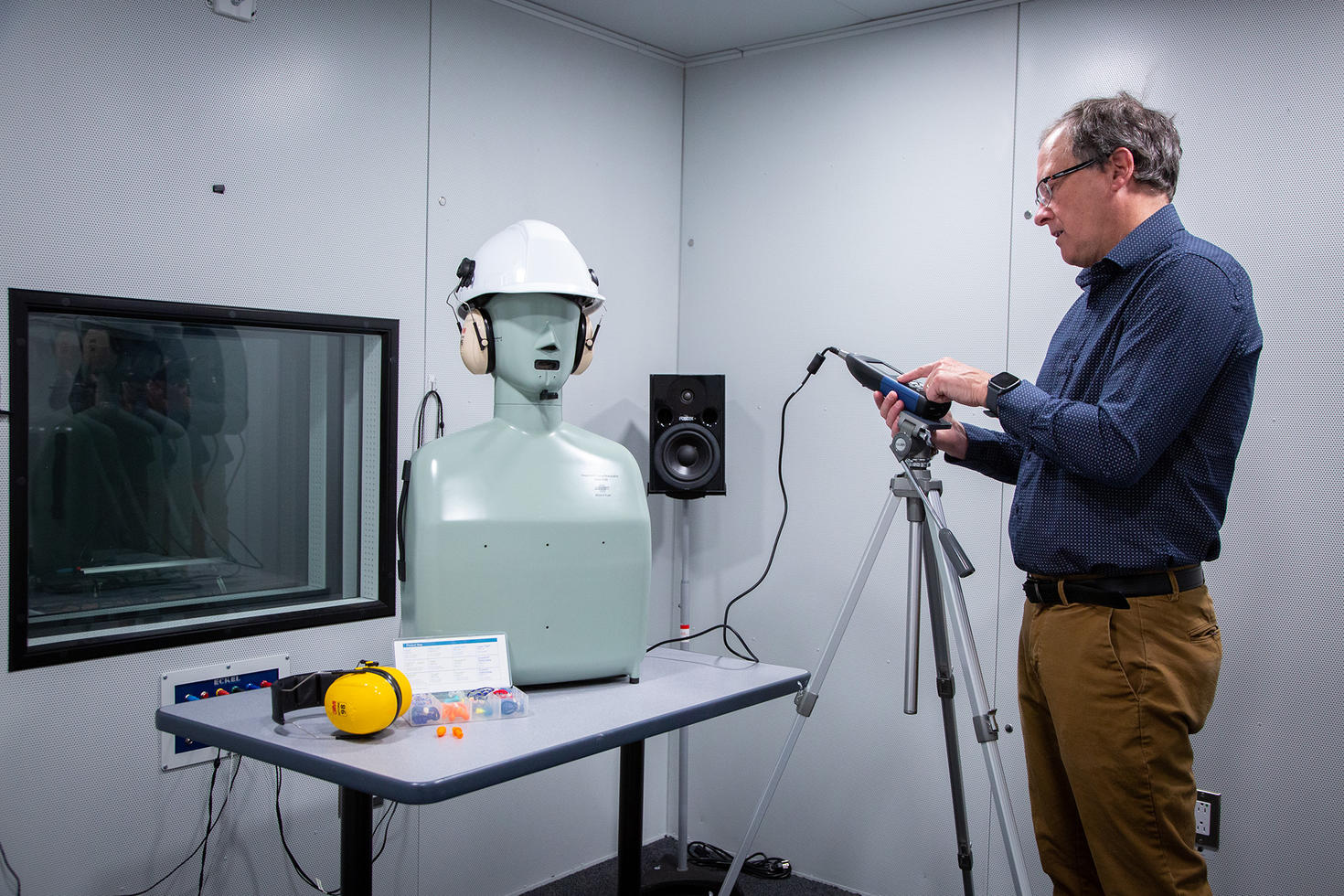 Christian Giguère running tests on a dummy head wearing a headset