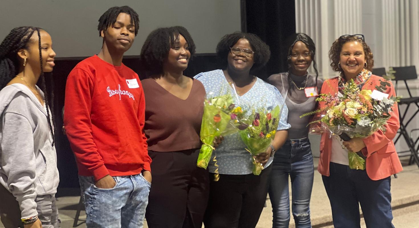 Senator Bernadette Clément (right) and clinical psychology doctoral candidates Wina Darius and Grace Jacob (centre) hold bouquets of flowers and pose with three students during the “My mental health, my family and me”  event at the University of Ottawa.