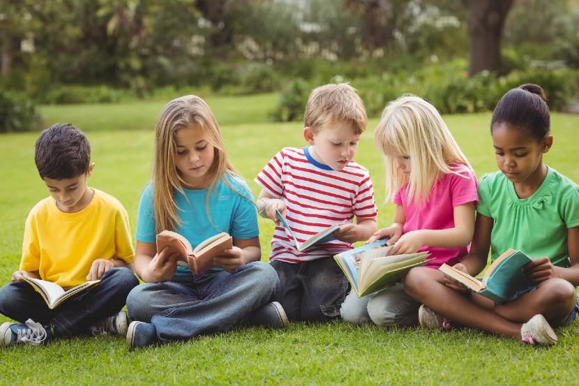 Children reading books outside