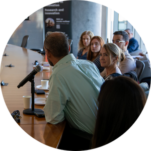 Participant speaking into a microphone during a roundtable discussion