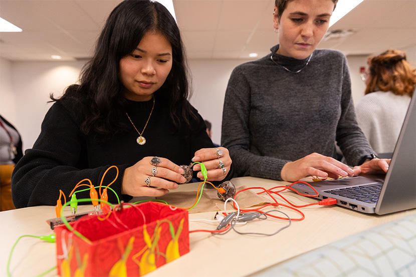 Teacher Education candidates with wires, donuts and a laptop.