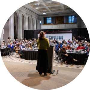 Researcher at a podium speaking to a room full of people