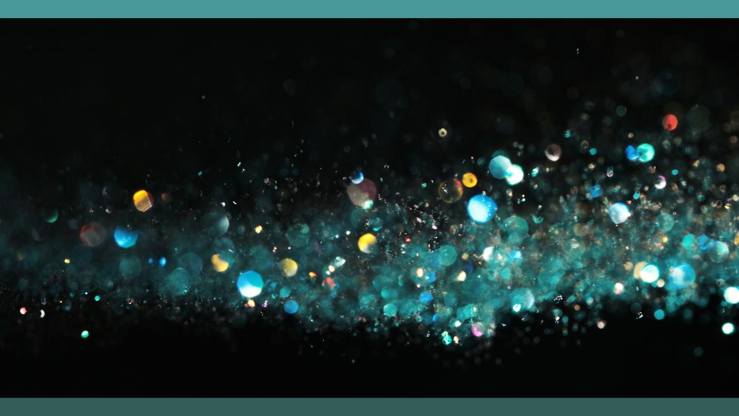 An abstract image of glitter falling on a black background.