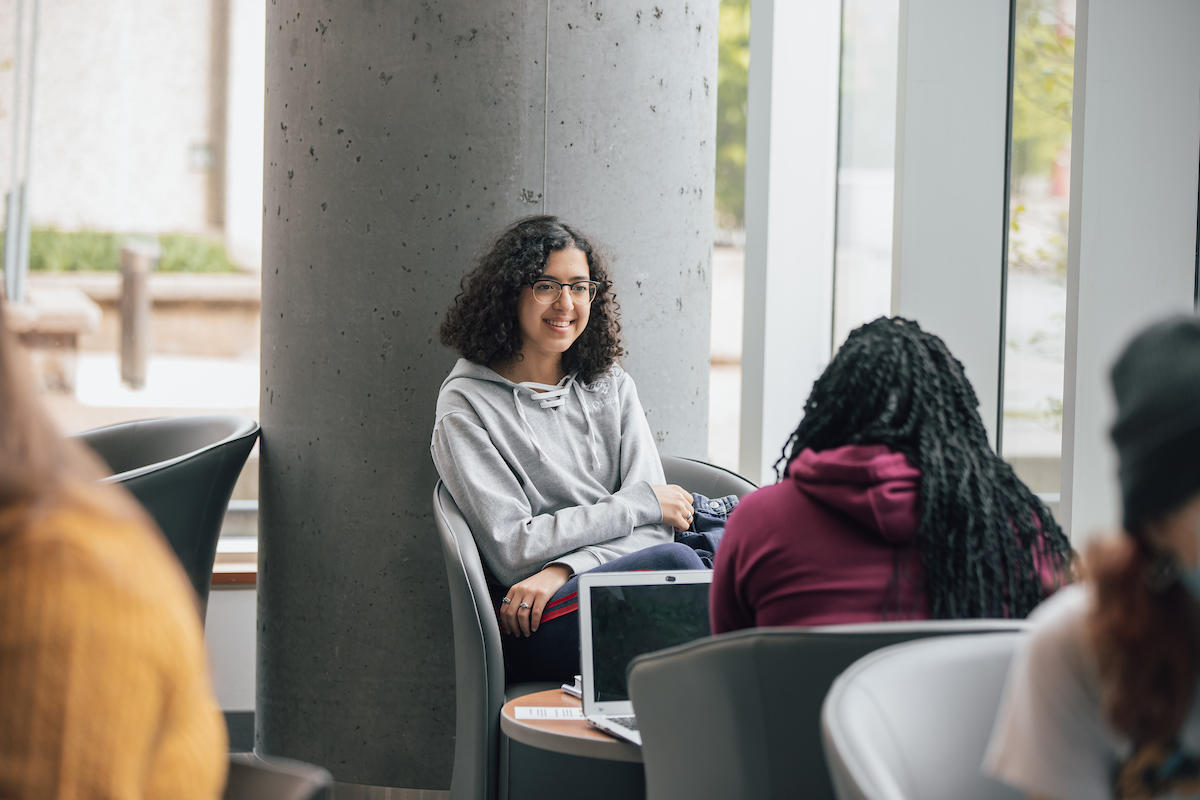 Students sitting and talking in a bright lounge area