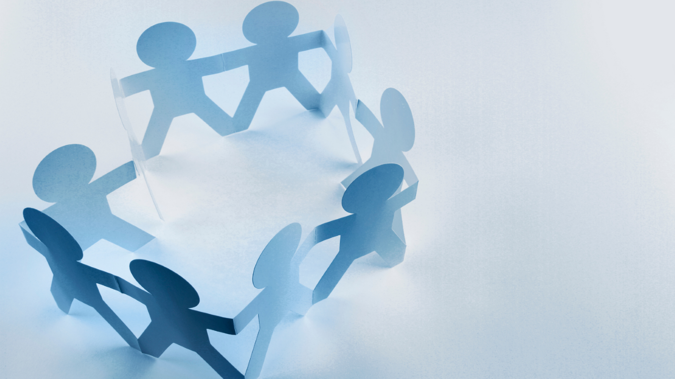 Paper cutouts holding hands.