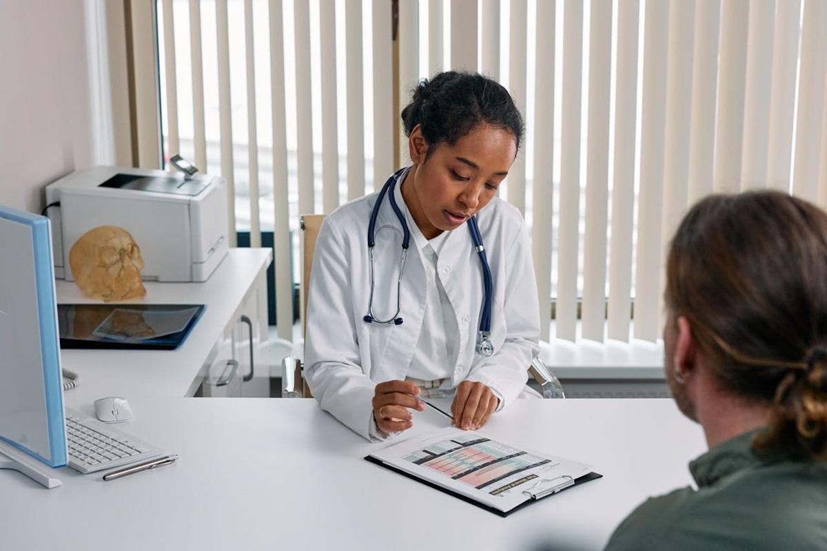 Female doctor writes notes during meeting with patient