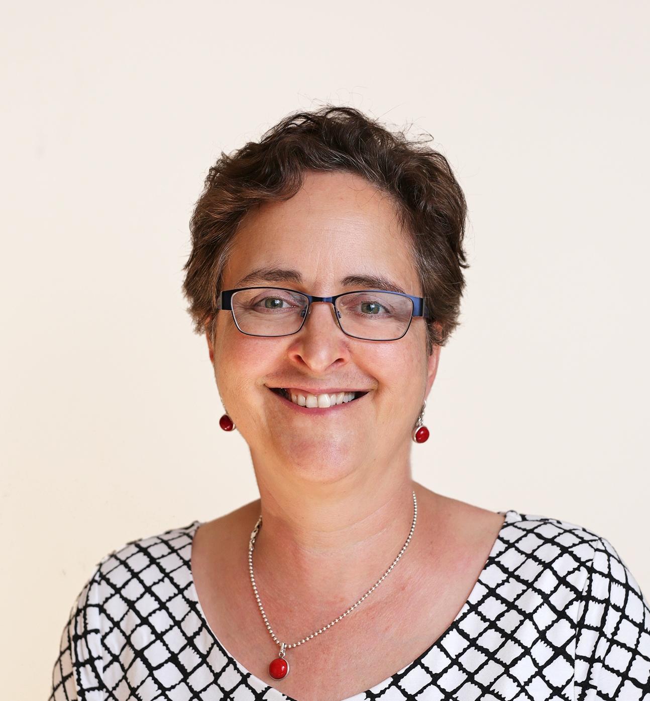 Professor Teresa Scassa in front of a beige backdrop