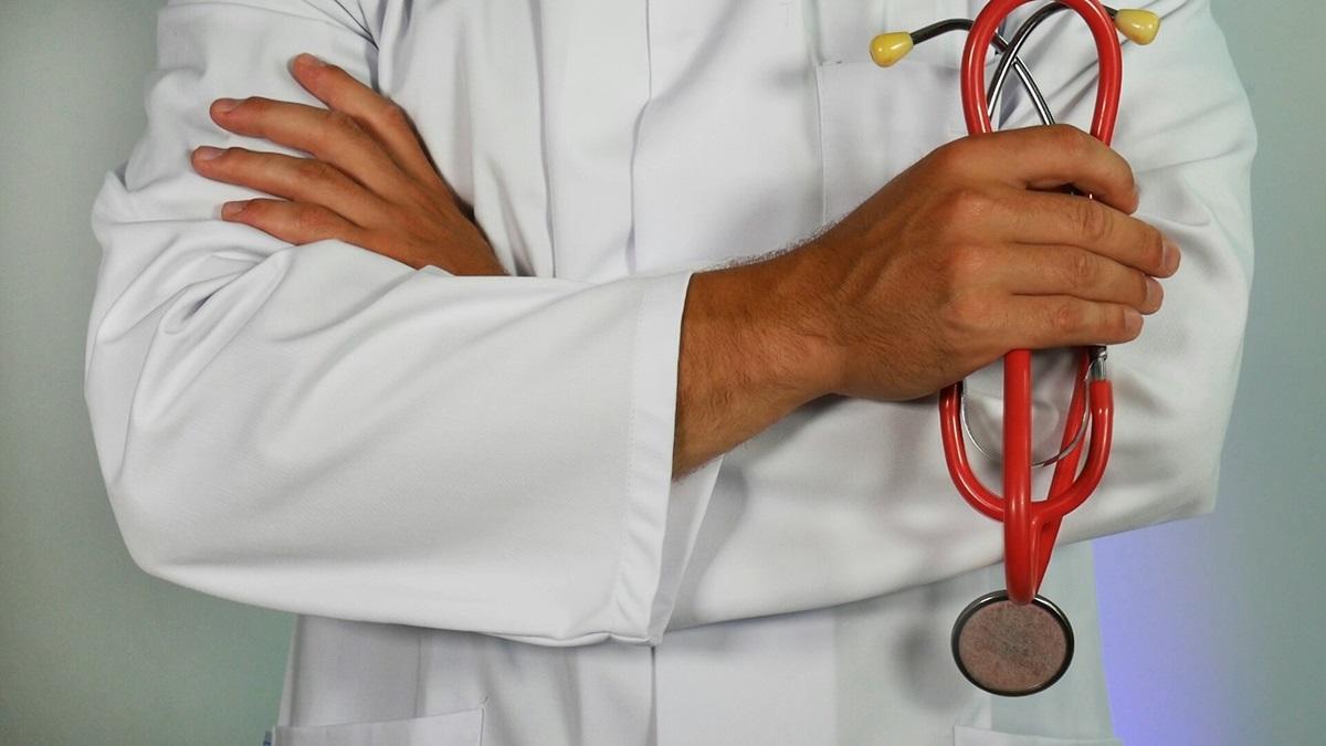 Doctor holding stethoscope with arms crossed