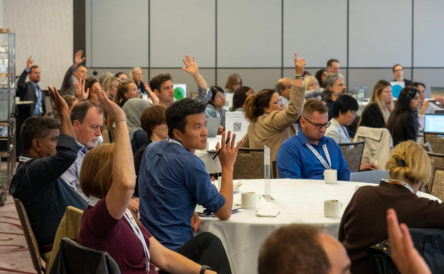 People at a conference raising their hands.