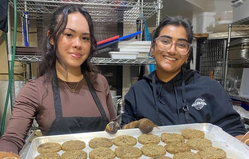 Nupacko team members Adrianna Ermacora, a first-year marketing student, and Divika Solanki, a second-year international management student, show off a tray of freshly baked, nutrient-rich cookies.