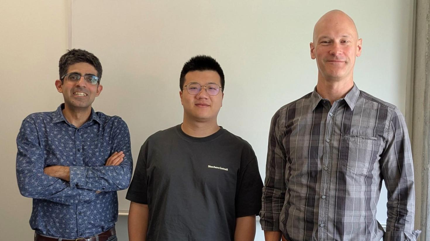 Professor Hadi Salmasian, postdoctoral fellow Yaolong Shen and Professor Alistair Savage stand against a white wall.
