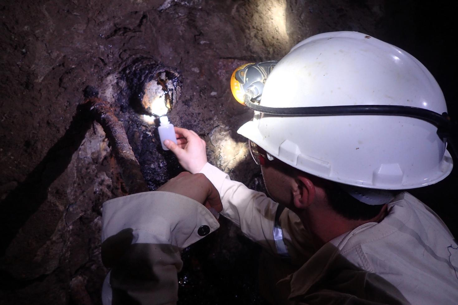Researcher collecting a sample in a mine. 