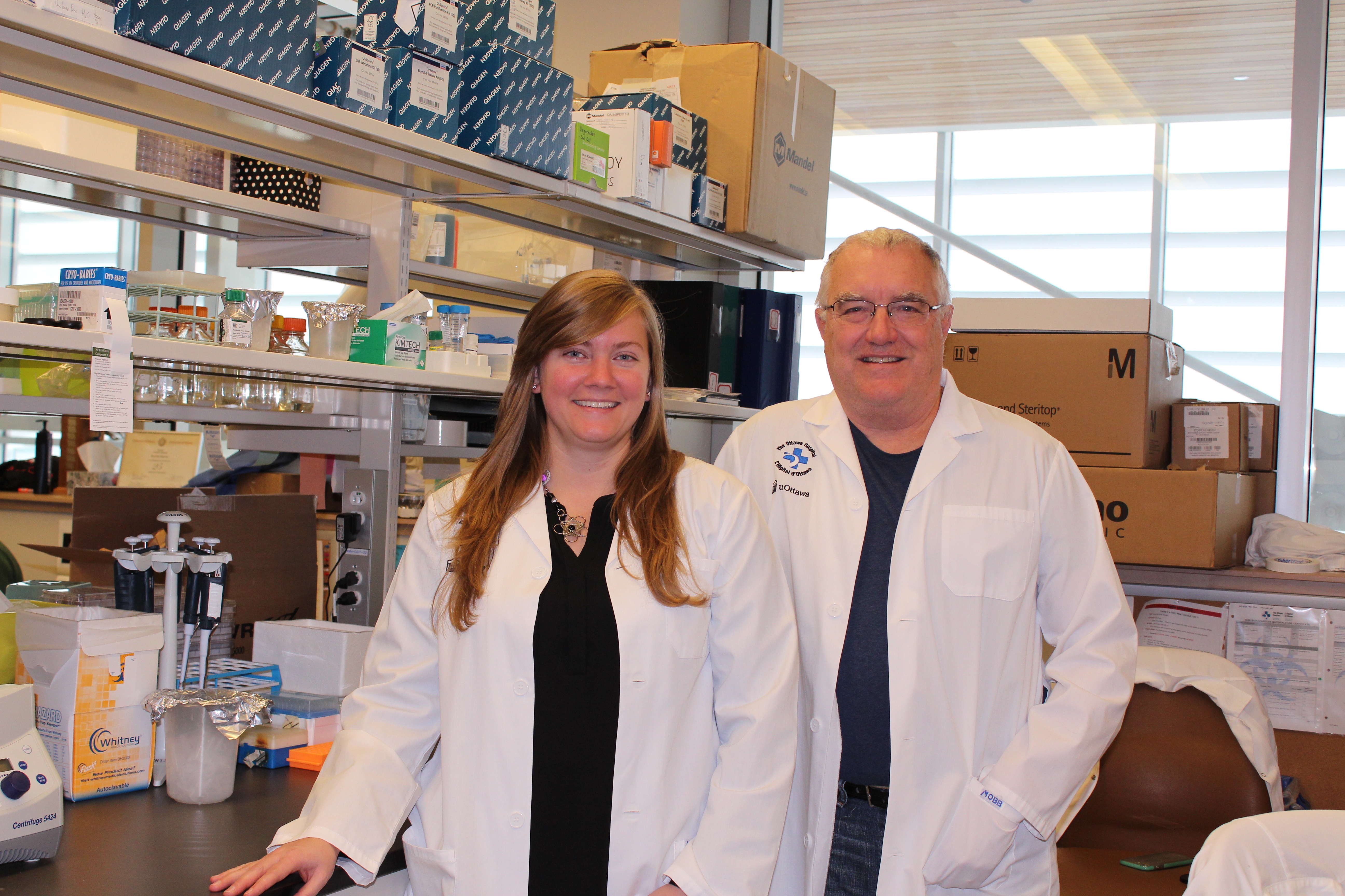 Marie-Claude Bourgeois-Daigneault and John Bell A woman and man stand, in white coats, in a research laboratory.