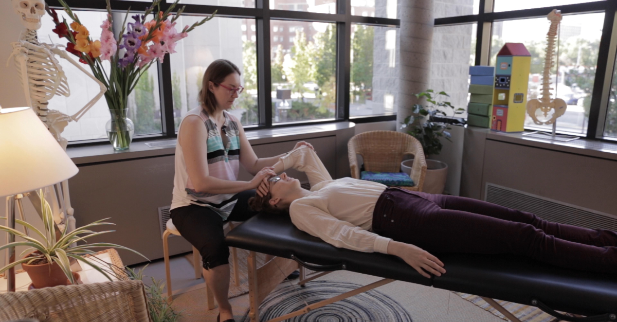 Une physiothérapeute fait faire un mouvement au bras d'une musicienne