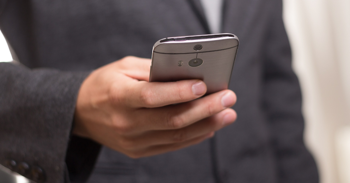Une jeune personne tenant un téléphone intelligent.