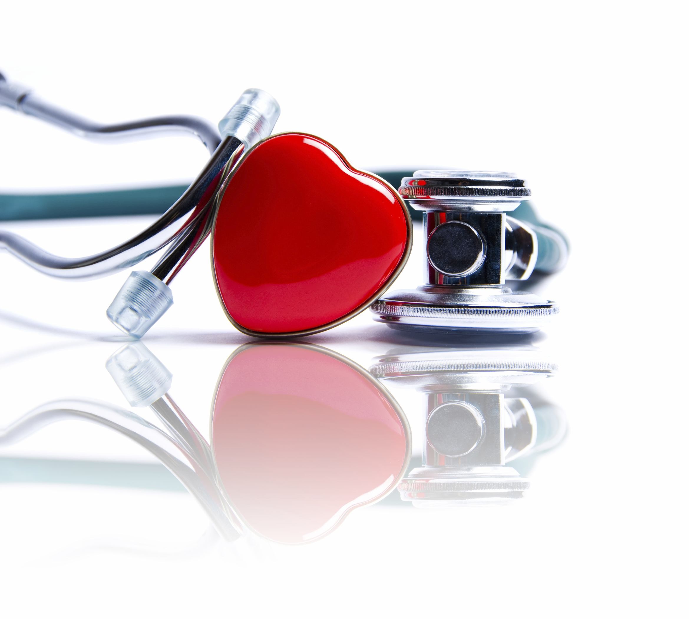 Stéthoscope sur une table avec un coeur rouge devant Stéthoscope sur une table avec un coeur rouge devant