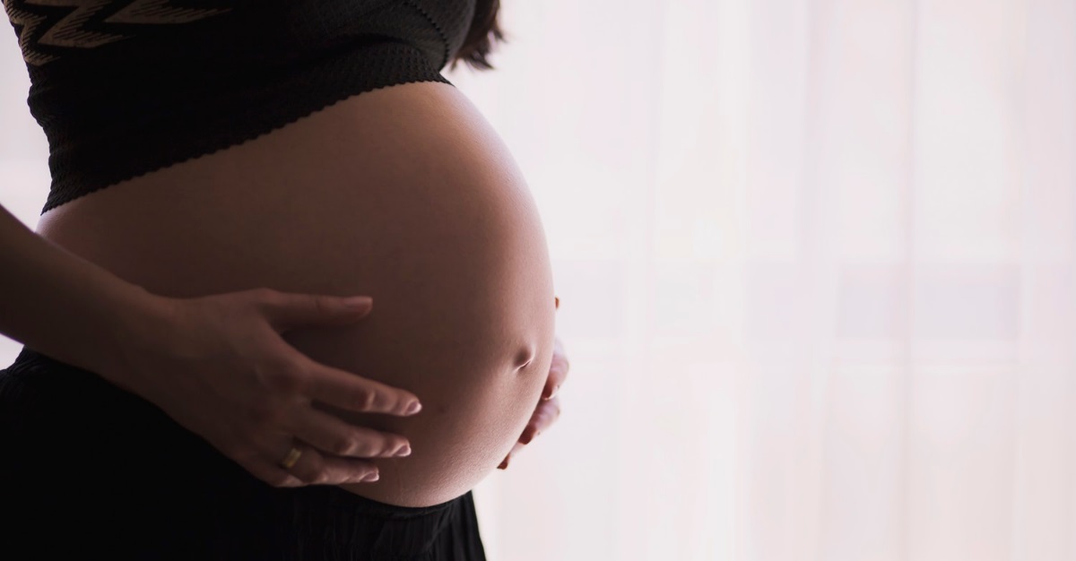 femme enceinte caressant son ventre