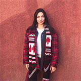 juliana_tpln devant un mur terre cuite qui porte une ceinture fléchée avec des drapeaux canadiens sur ses épaules