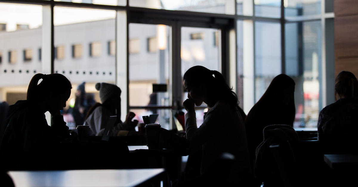 Étudiants dans un café à contre-jour.