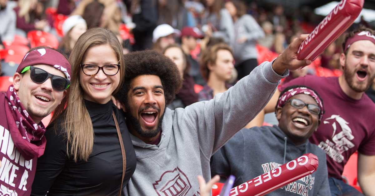 Peter Soroye avec un afro encourageant les Gee-Gees lors d'un match Panda