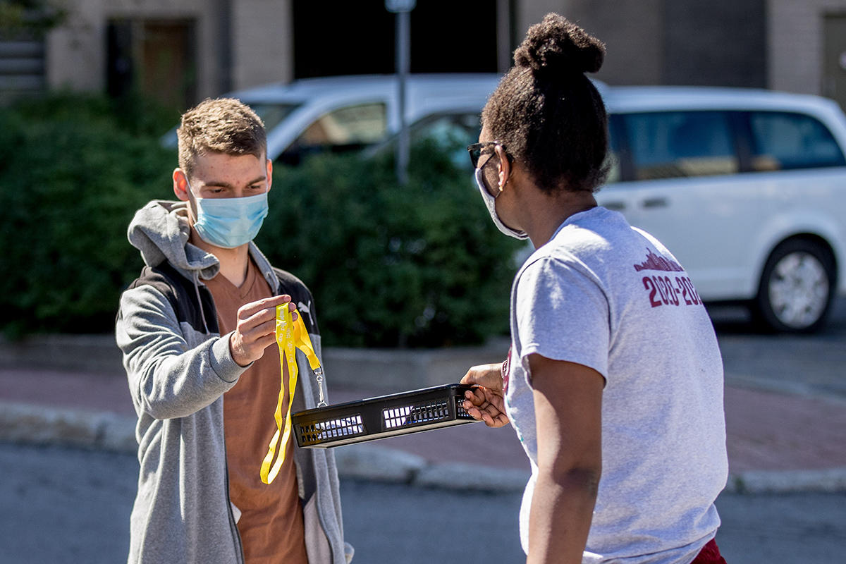 New student resident takes keys from a tray for his room