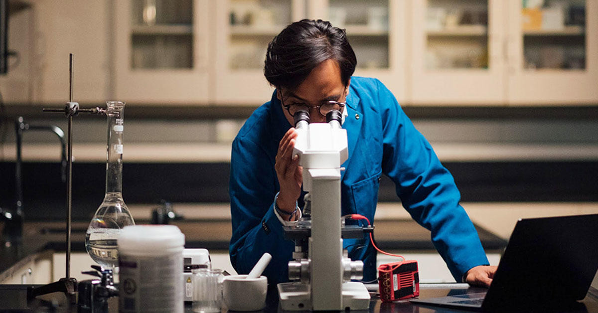 Un homme utilisant un microscope 