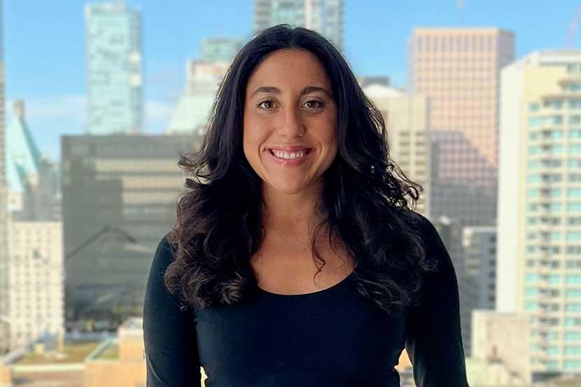 Malorie standing with buildings in the background