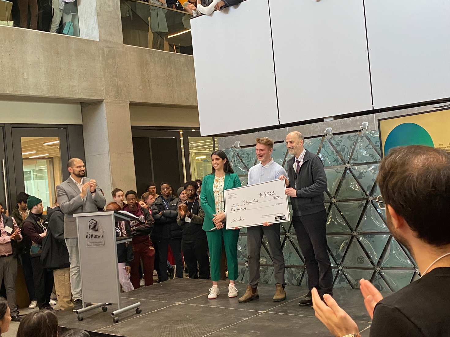 Gabe Braden recevant un chèque de 5 000 $ pour la première place remportée par son équipe.