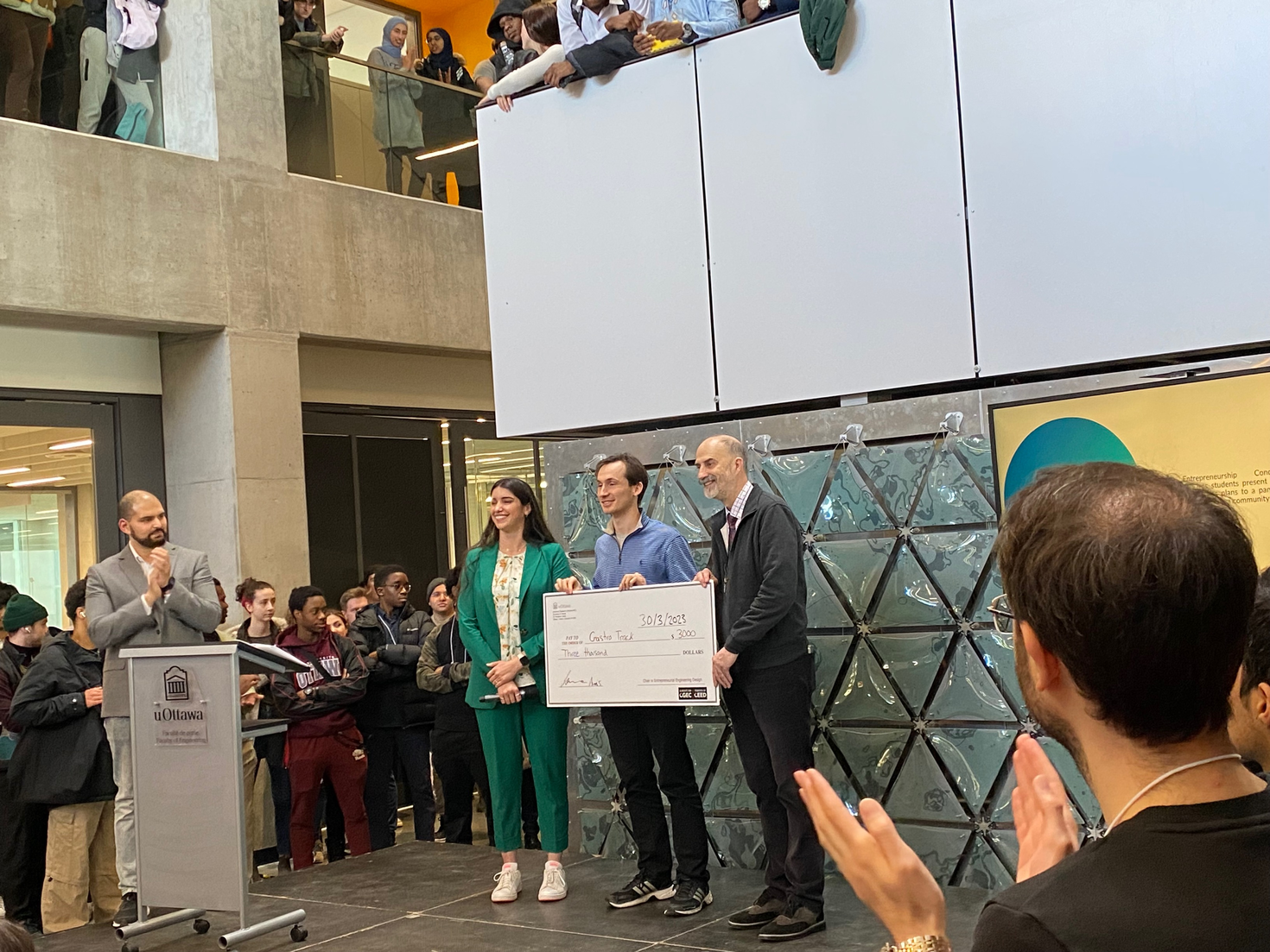 Aidan MacAdam recevant un chèque de 3 000 $ pour la deuxième place remportée par son équipe.