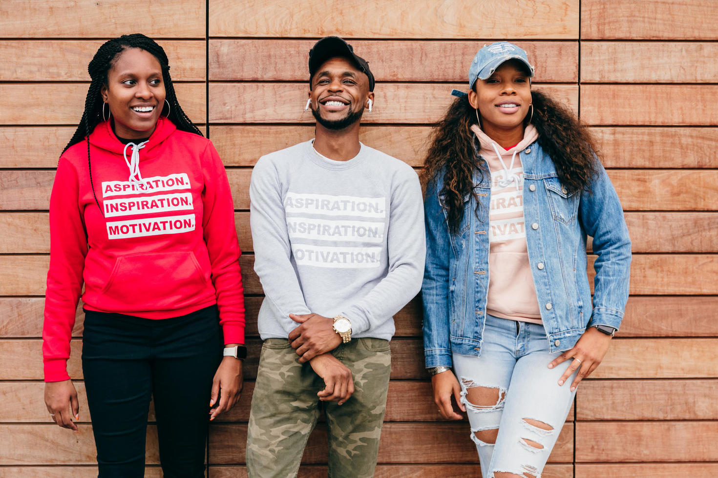 Groupe d'amis divers debout devant un mur