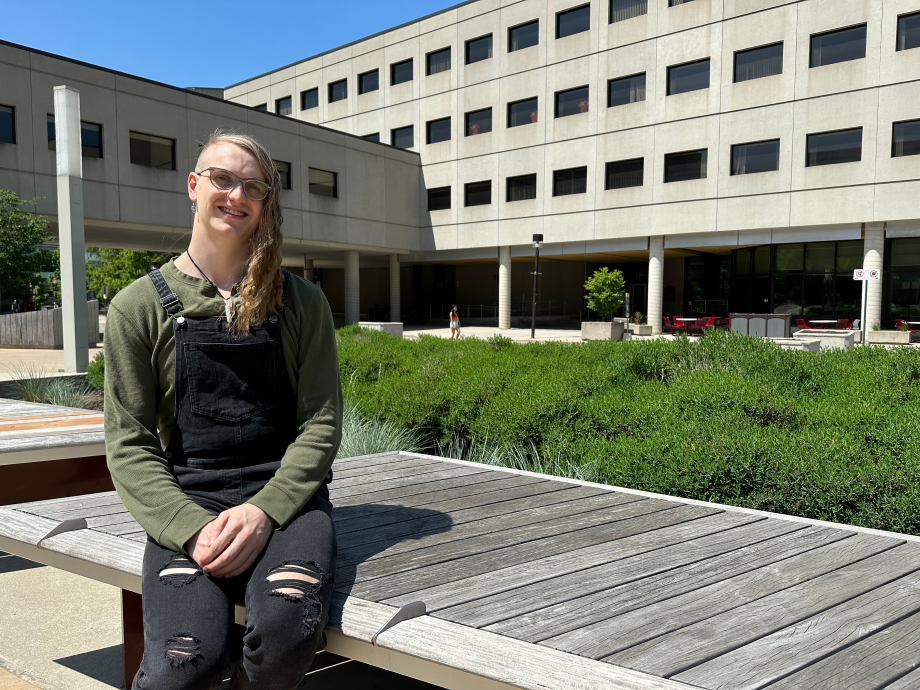 Zachary Wynen assis sur un banc devant le bâtiment Lamoureux