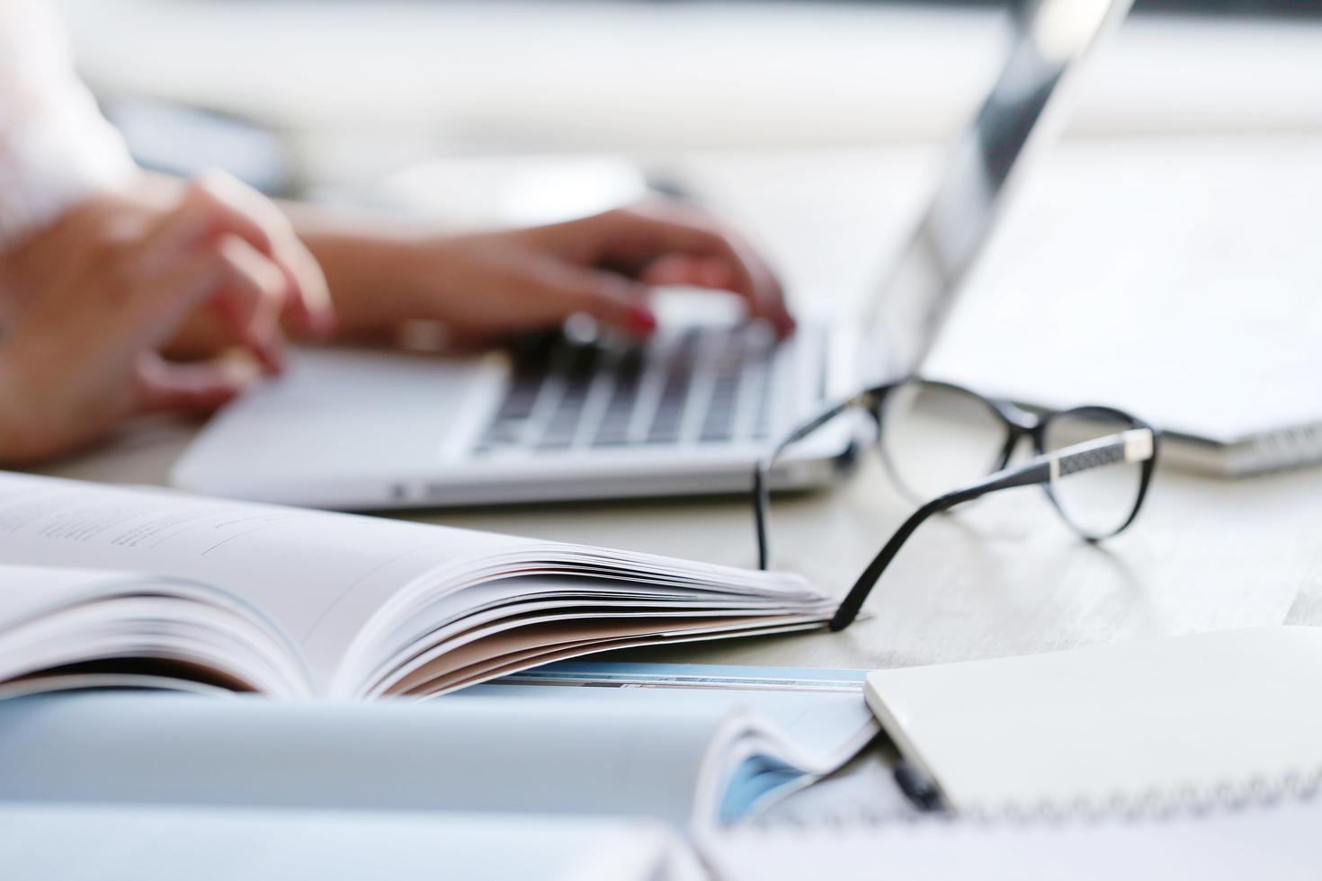 mains tapant sur un ordinateur portable sur un bureau