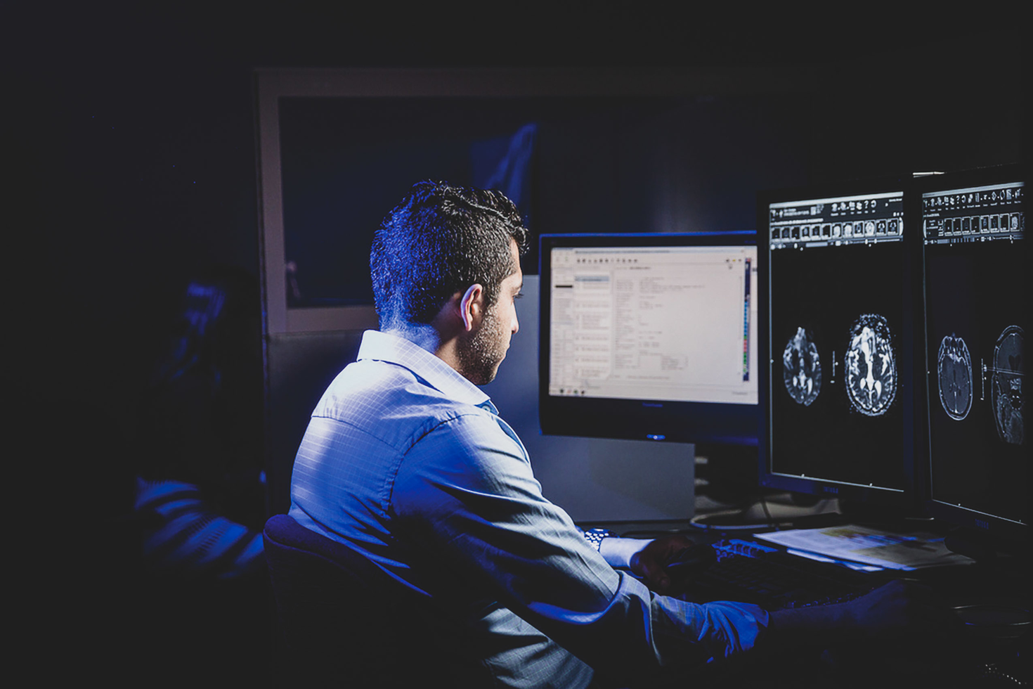 Researcher studying screen with brain imaging on it.
