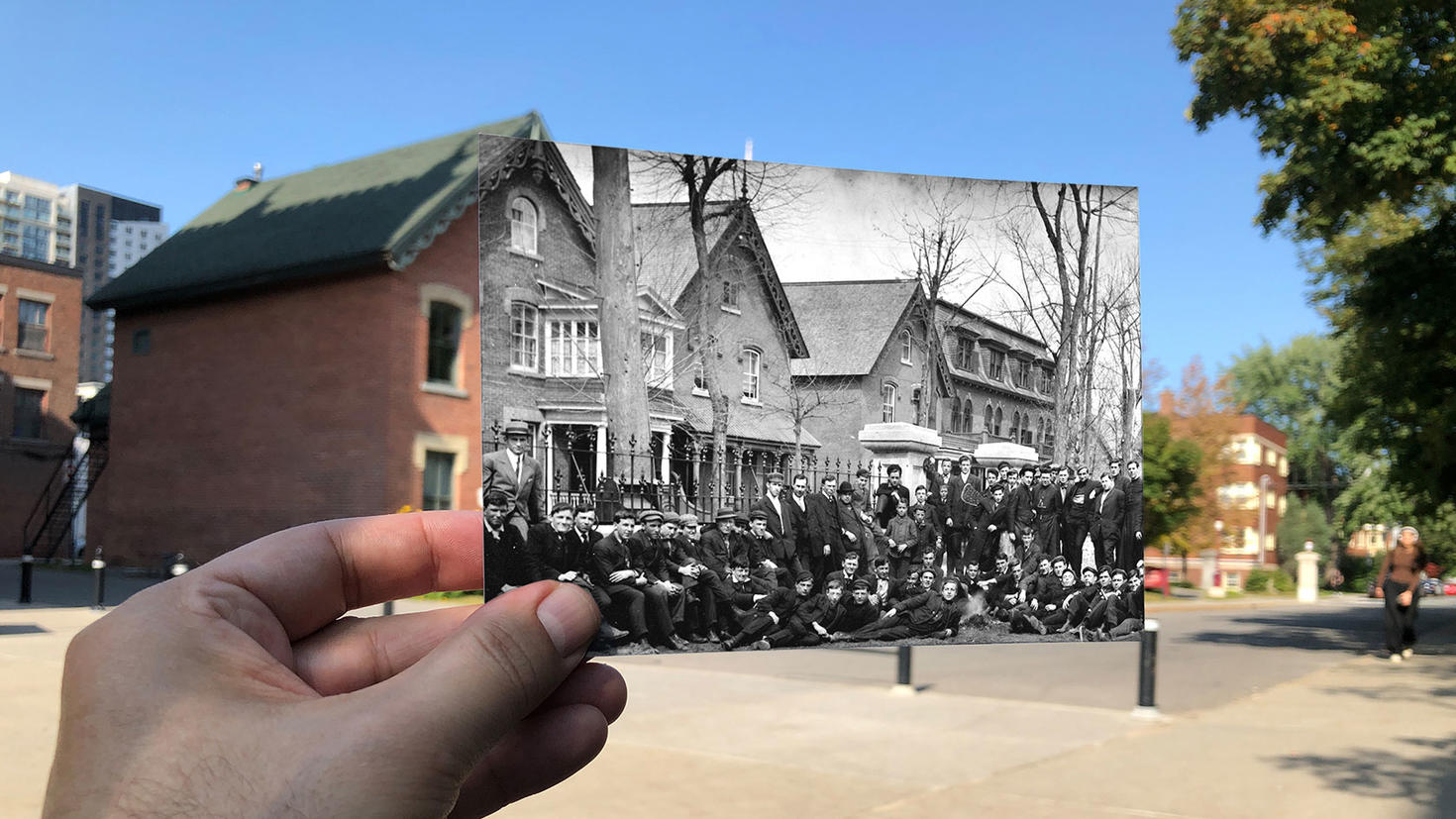 Le pavillon des diplômés avec une main tenant une vieille image de ce à quoi le pavillon des diplômés ressemblait au milieu des années 1800.
