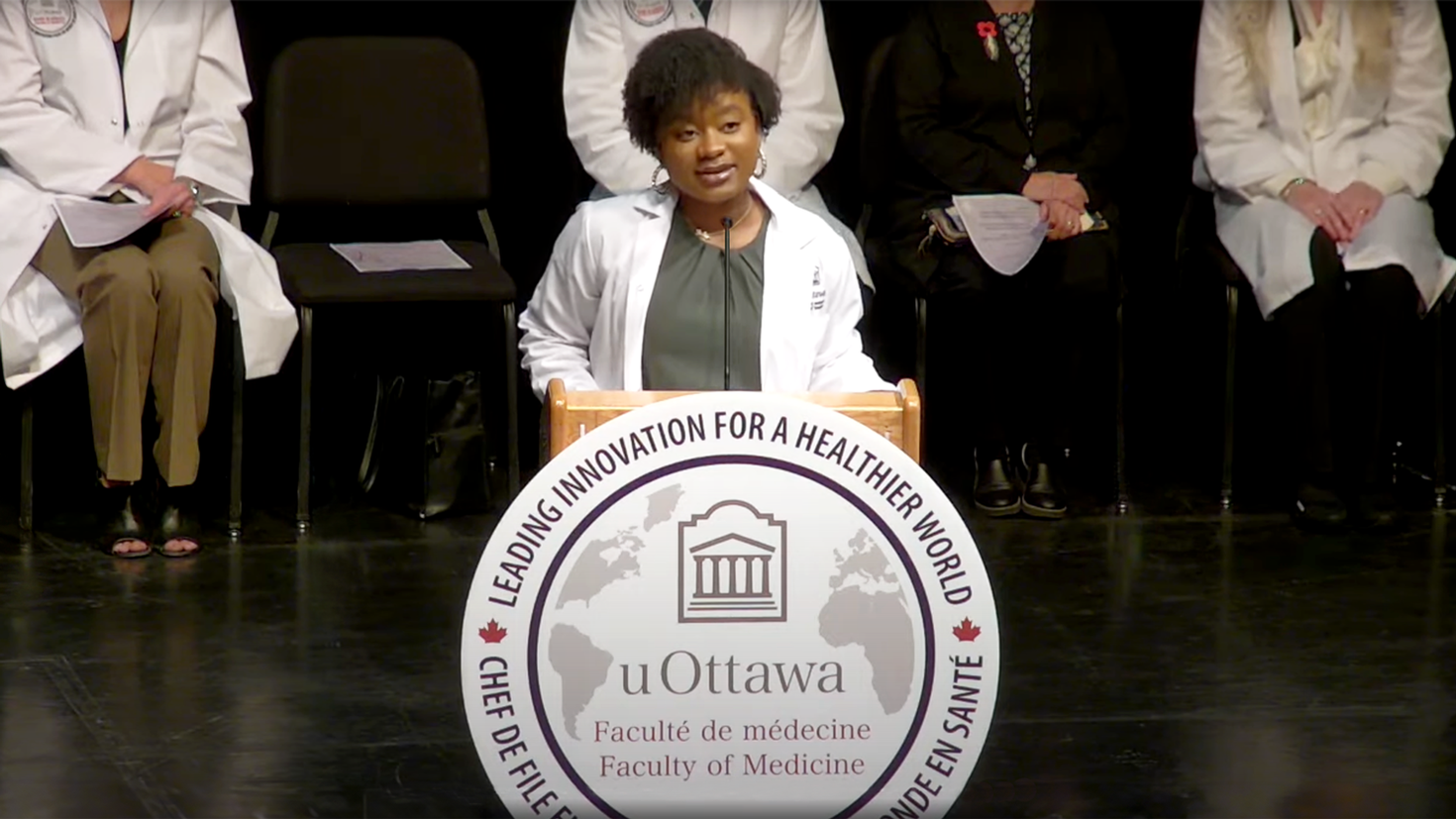Une étudiante en médecine parlant à un podium.