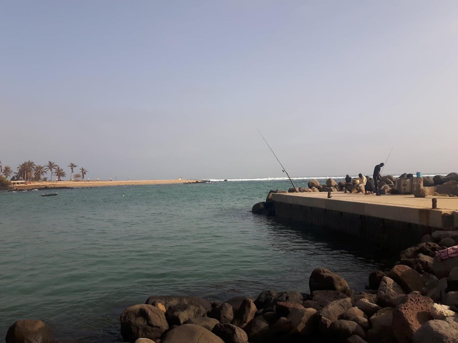 A picture of the port of Dakar circled wih small rocks and facing another island