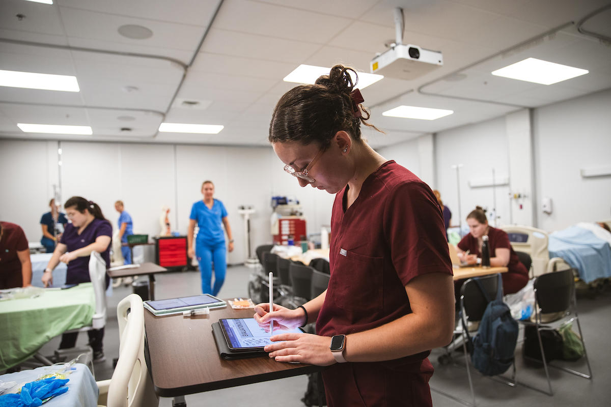 Medical resident using tablet in simulation center