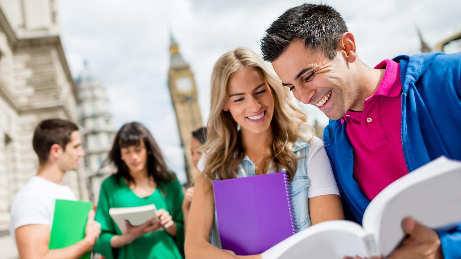 People reading a book in front of the Big Ben