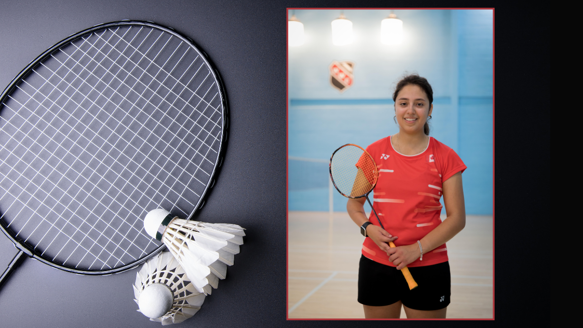 A woman holds a badminton racket and stands on a badminton court