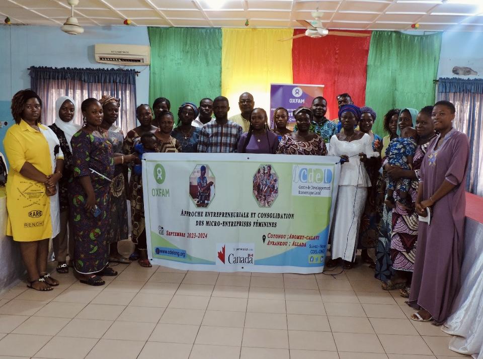 Groupe de personnes avec le drapeau du Bénin en arrière-plan. Groupe tenant une affiche au centre.