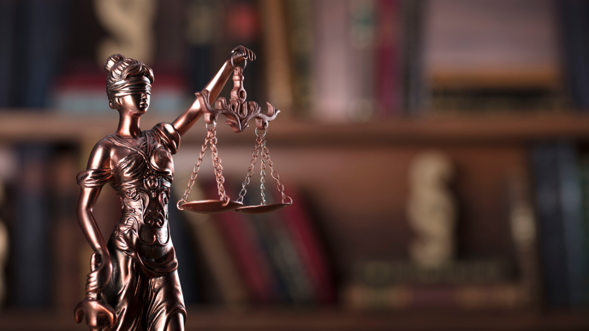 statue of  woman, blindfolded and holding a set of scales in one hand and a sword in the other