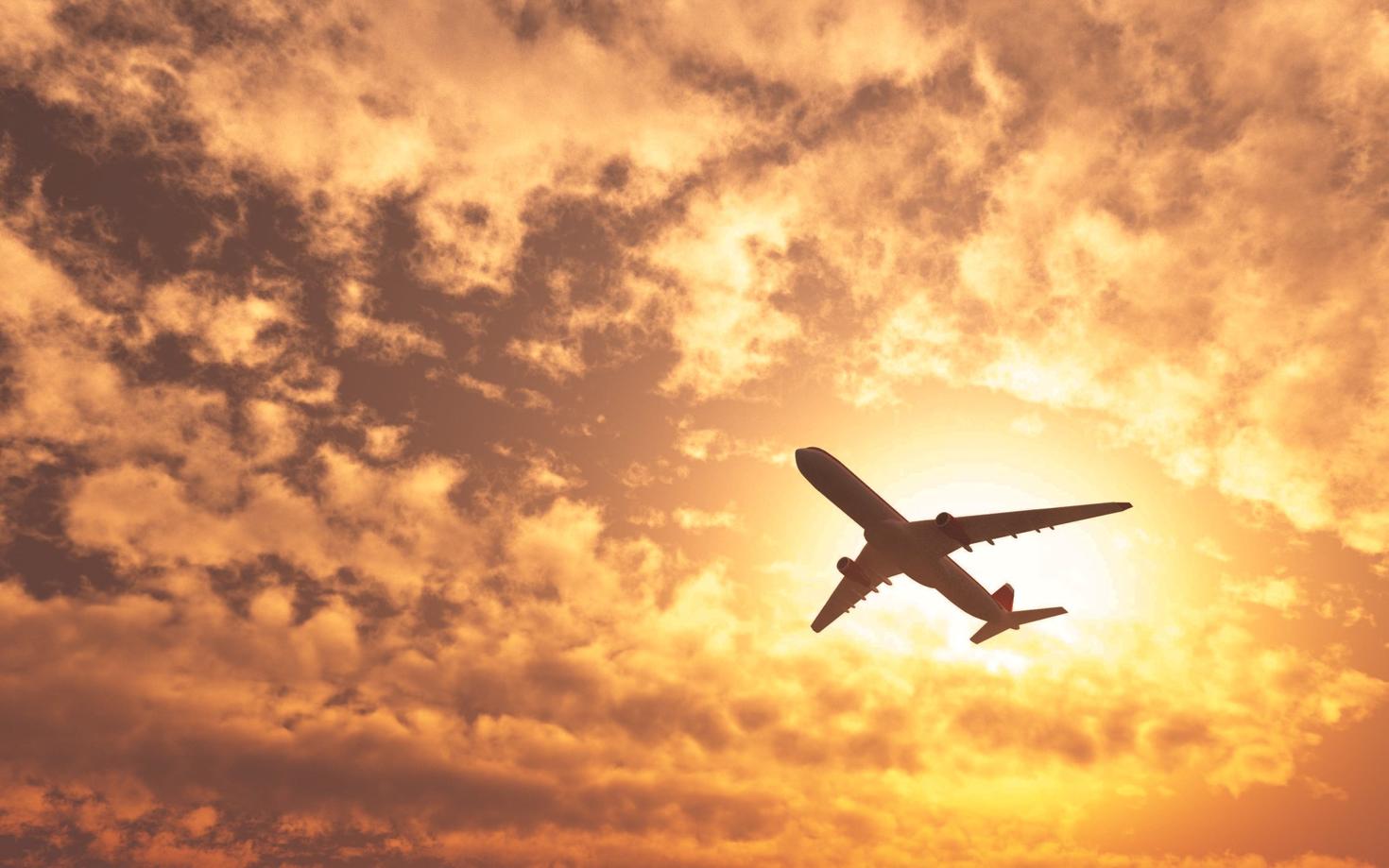 plane passing by sun on cloudy day