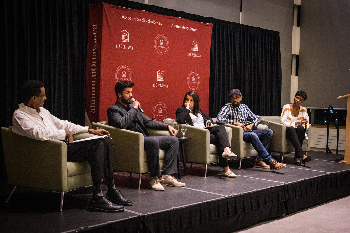 Quatre orateurs assis sur scène, participant à un panel