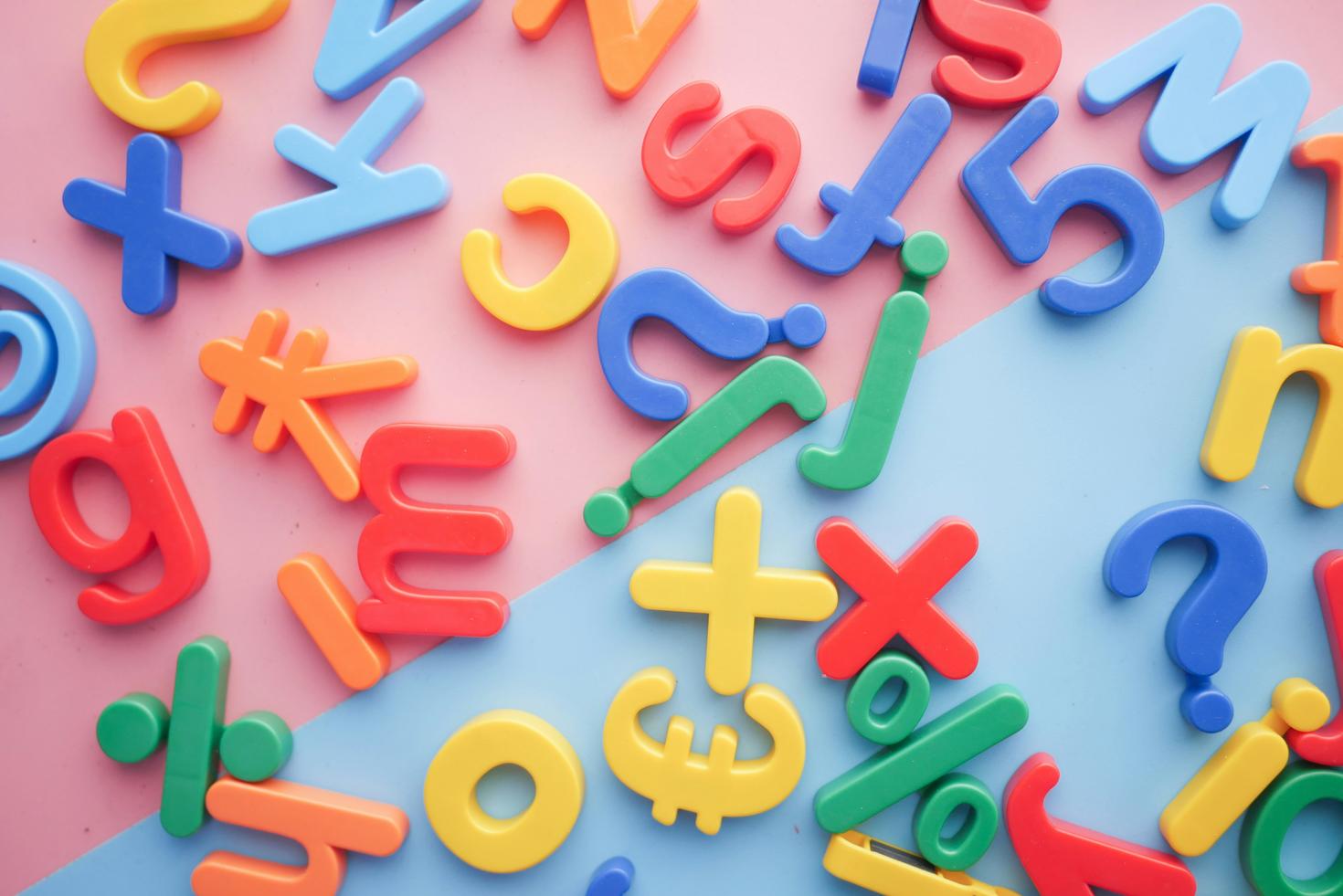 Mix of letters and signs in different colors on a pink and blue background