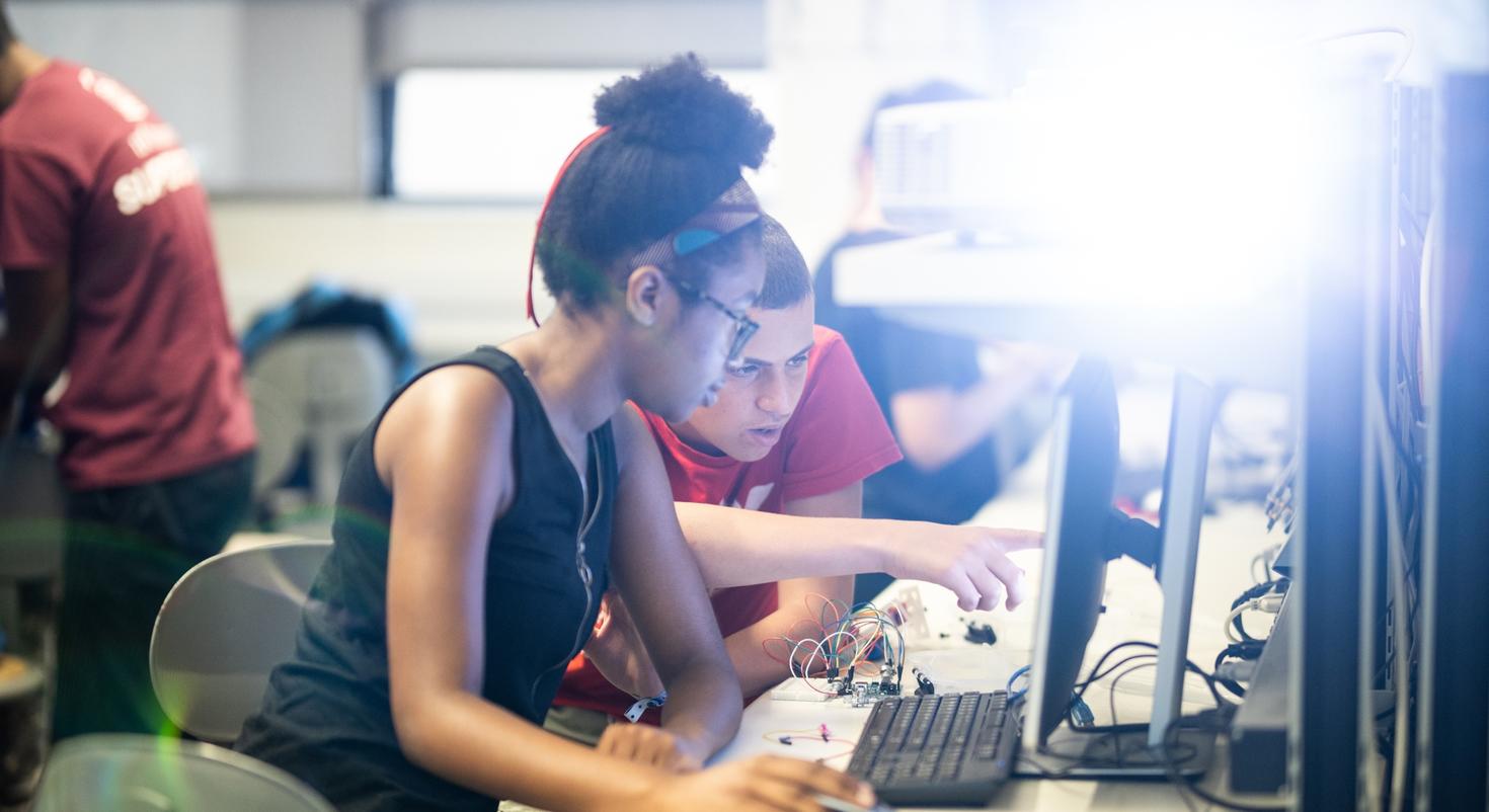 2 étudiants face à un ordinateur de bureau