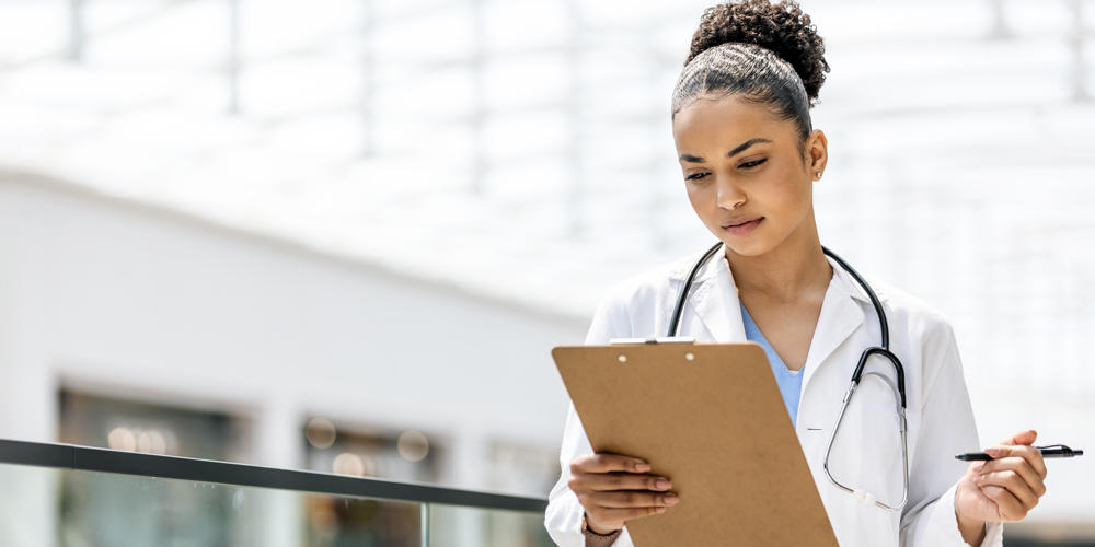 Female Doctor looking at chart on clipboard