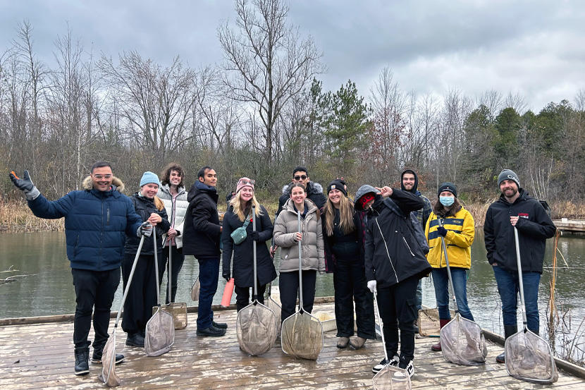 People on a dock in a marsh holding nets.