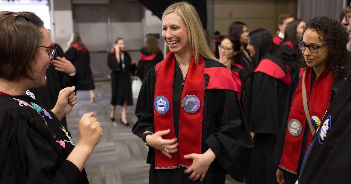  Students dressed in gowns at graduation.