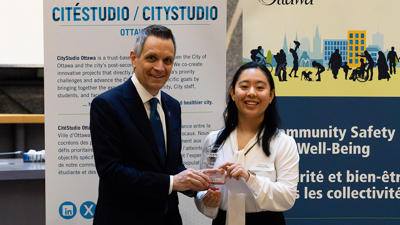 The mayor of Ottawa handing an award to a person