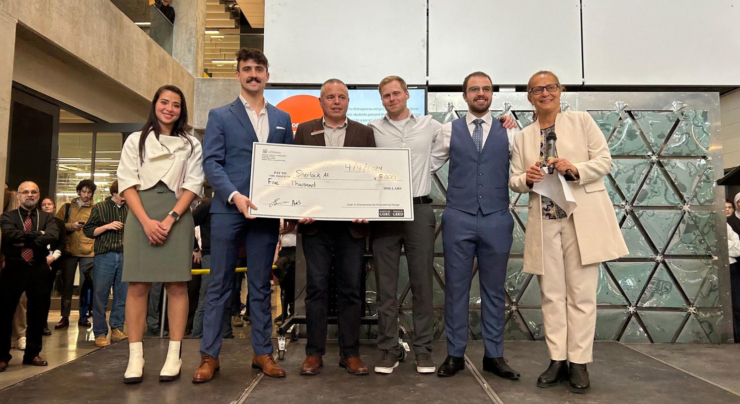 A group holding a prize money certificate.